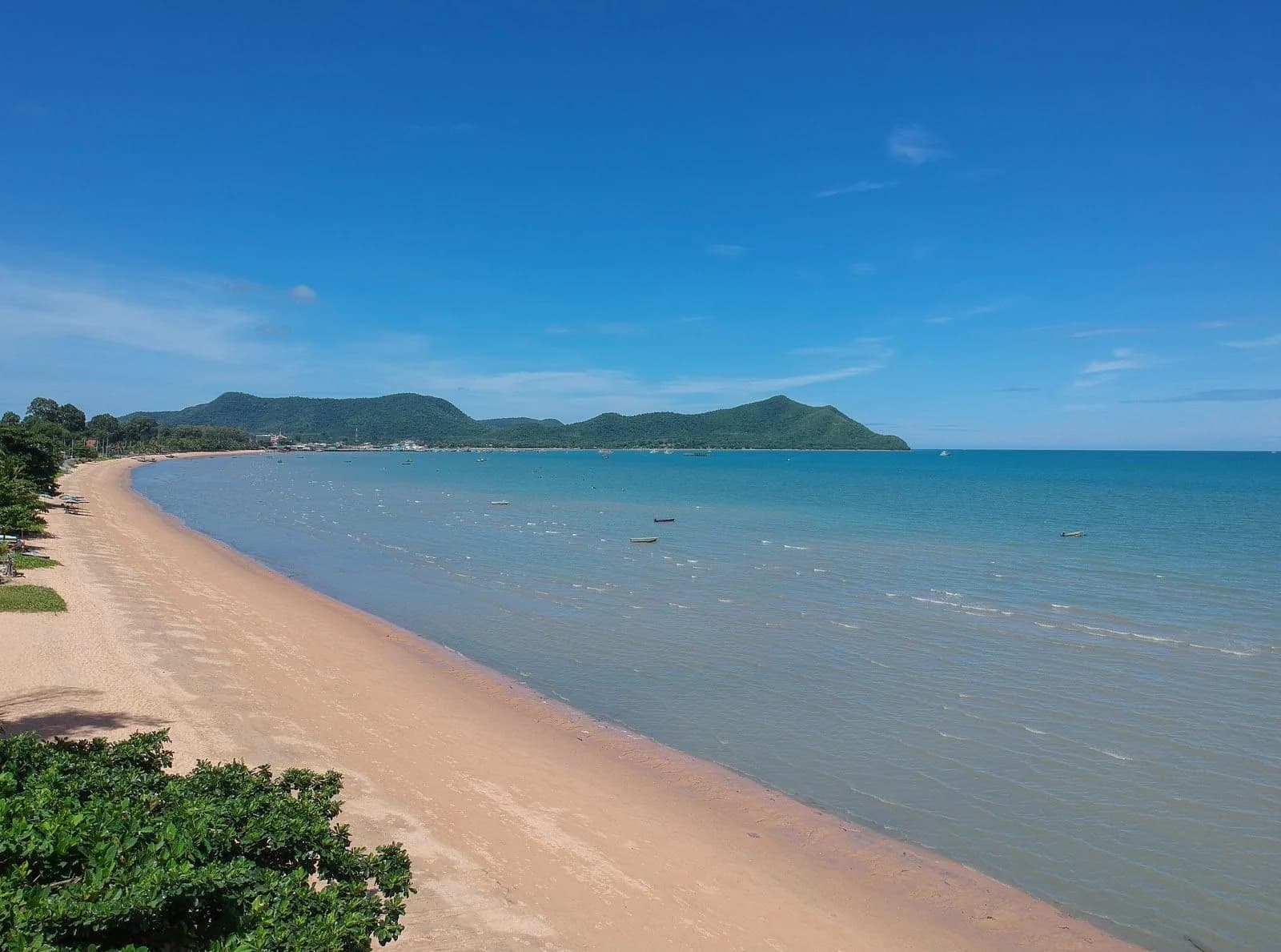 หาดบางเสร่ทอดโค้งไปทางแหลม มีเรือประมงจอดอยู่ไม่ไกลจากฝั่ง